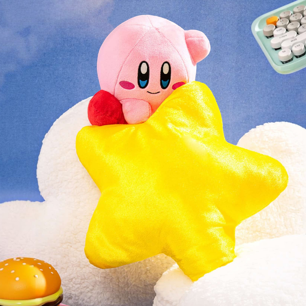 Otaku Boxes 10.5-inch Kirby plush holding a shiny yellow Warp Star with red feet on a fluffy white cloud background